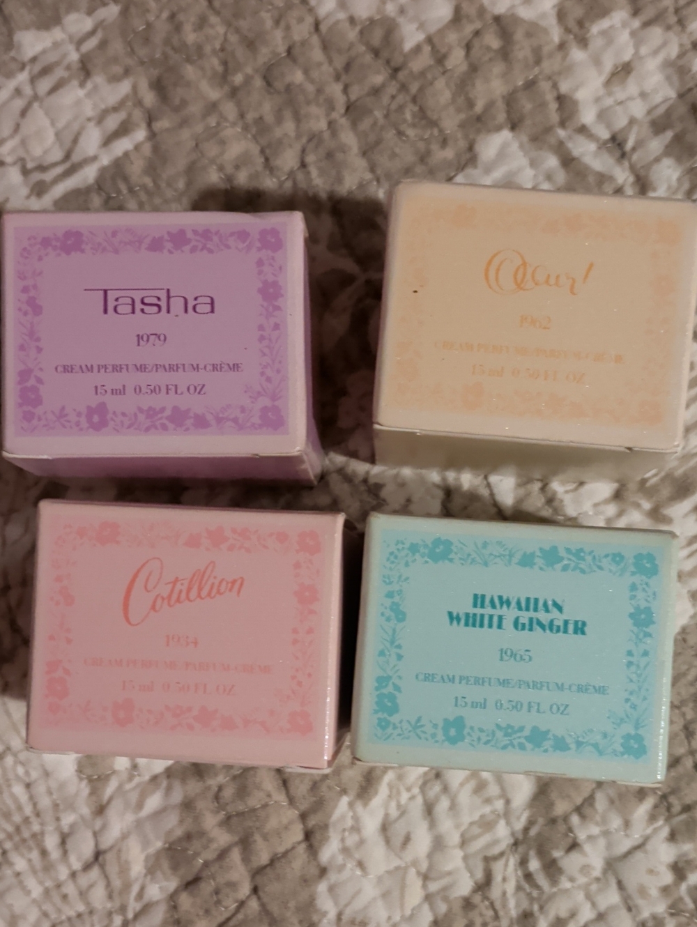 Avon cream perfumes in pastel purple, peach, pink, and aqua boxes